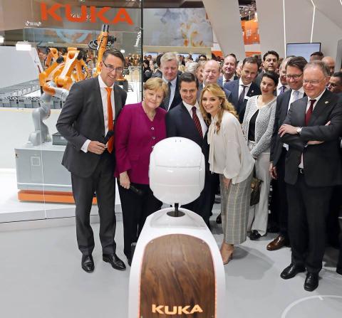 German Chancellor Angela Merkel observes robots at Hannover Messe. 